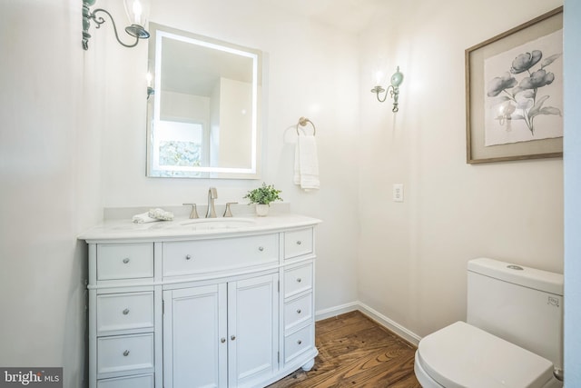 2407 Mare Ln, Oakton, VA 22124 - bathroom featuring wood finished floors, vanity, baseboards, and toilet