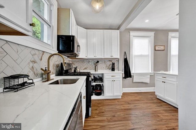 kitchen featuring a sink, stainless steel appliances, white cabinetry, and a wealth of natural light