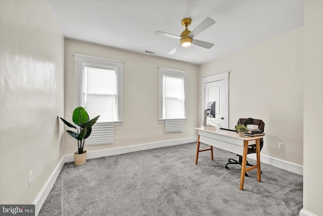 carpeted home office with baseboards, a ceiling fan, and visible vents