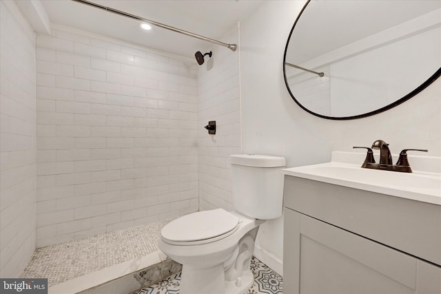 bathroom featuring vanity, recessed lighting, a tile shower, and toilet