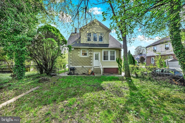 back of house with a yard, a chimney, a fenced backyard, and entry steps