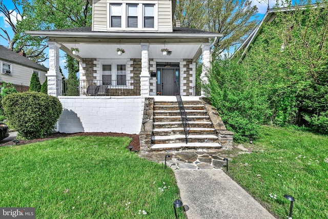 view of front of property with covered porch and a front yard