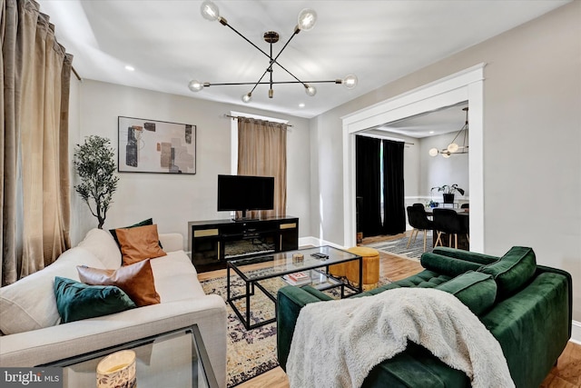living area with an inviting chandelier, recessed lighting, baseboards, and wood finished floors