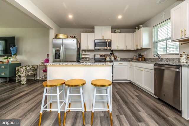 kitchen featuring a kitchen island, white cabinets, and stainless steel appliances