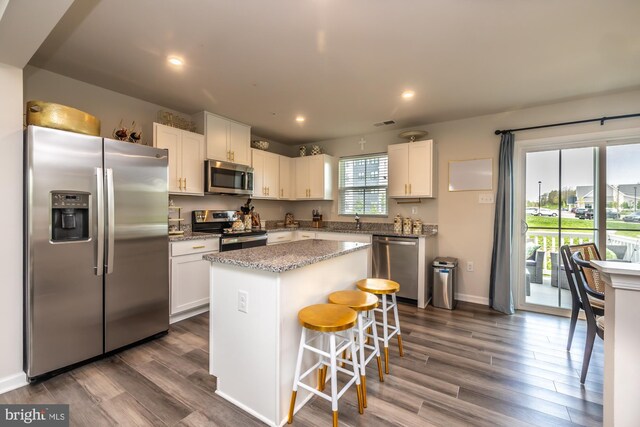 kitchen with a kitchen island, white cabinets, and appliances with stainless steel finishes