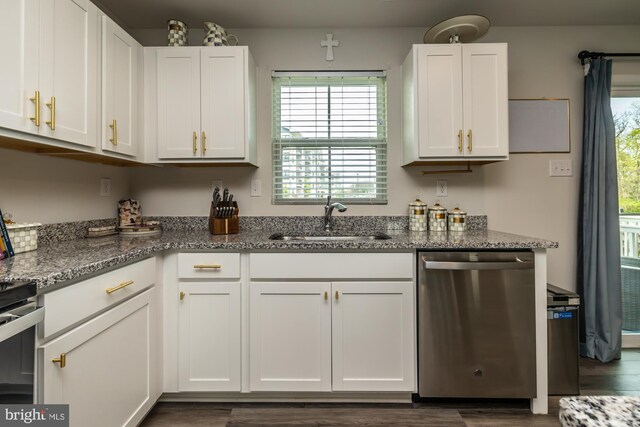 kitchen with a sink, stone counters, appliances with stainless steel finishes, and white cabinets