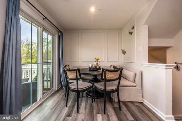 dining space with baseboards and wood finished floors
