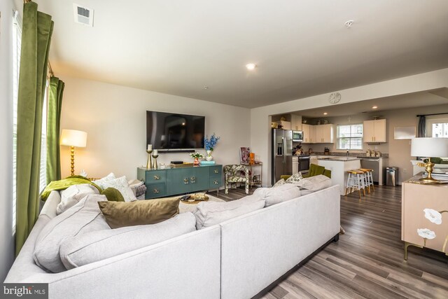 living room featuring recessed lighting, visible vents, and dark wood-type flooring