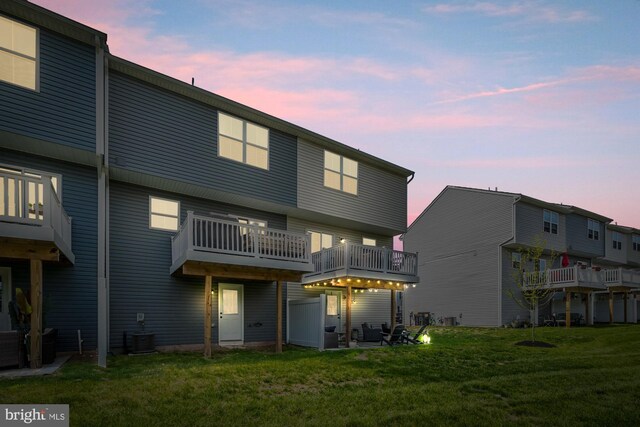 back of property at dusk with a yard and cooling unit