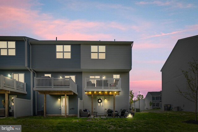 rear view of house with a lawn and cooling unit