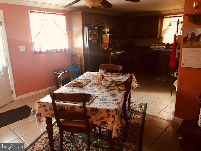 dining space with light tile patterned floors, baseboards, ornamental molding, and a ceiling fan