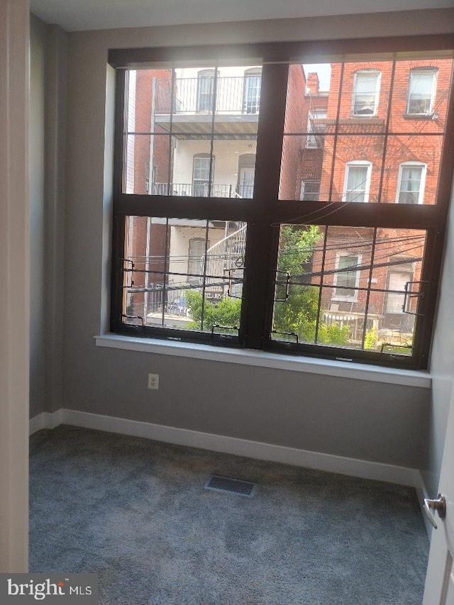 empty room featuring visible vents, baseboards, and carpet floors