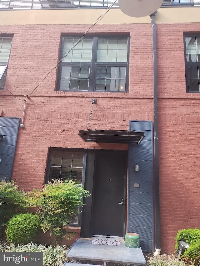 entrance to property featuring brick siding
