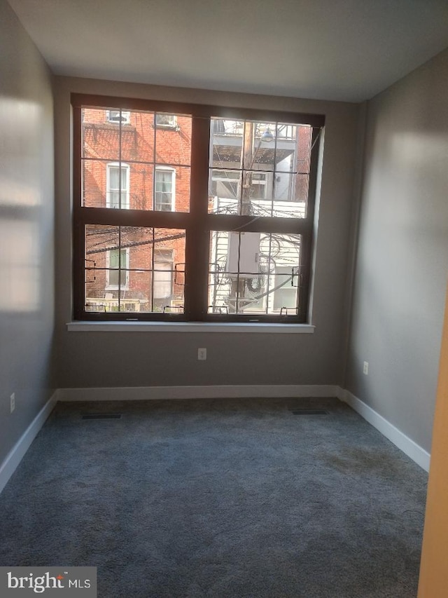 carpeted empty room with baseboards and plenty of natural light
