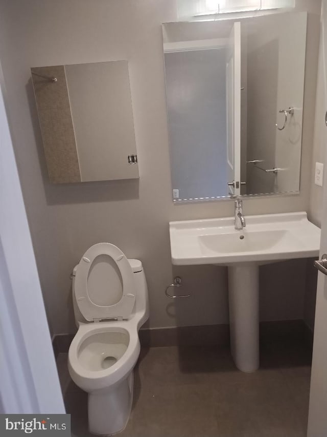 bathroom with baseboards and toilet