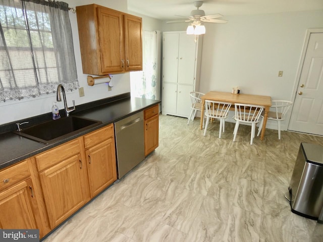 kitchen featuring ceiling fan, dark countertops, a sink, dishwasher, and brown cabinetry