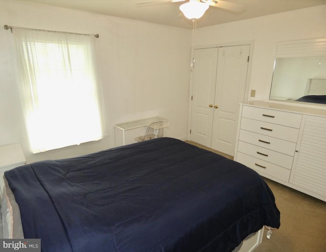 carpeted bedroom featuring ceiling fan and a closet
