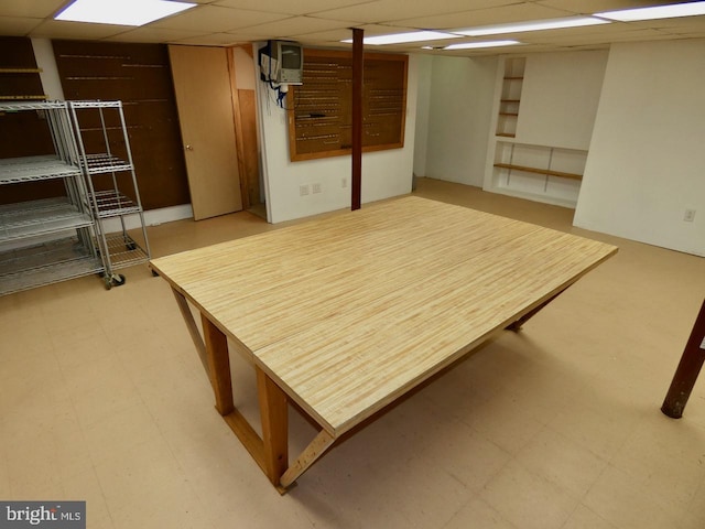 finished below grade area featuring tile patterned floors and a drop ceiling
