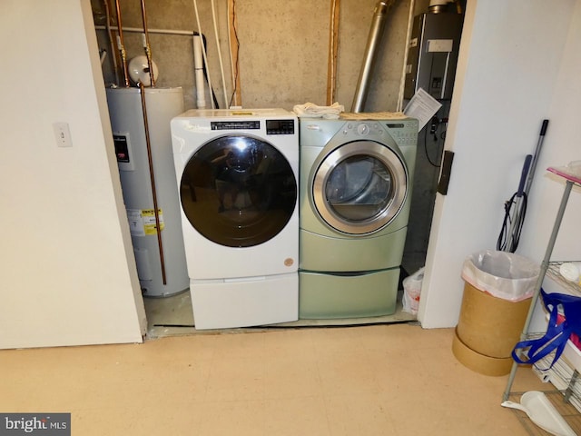 washroom with tile patterned floors, laundry area, washing machine and dryer, and electric water heater
