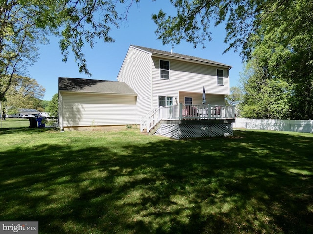 back of house featuring a lawn, fence, and a deck