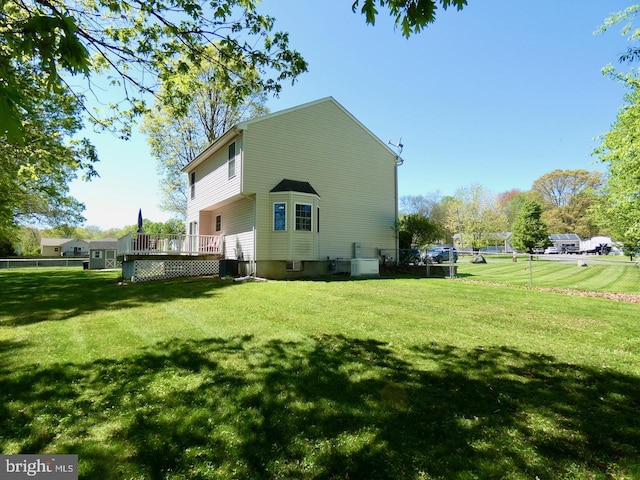 back of house with a yard, fence, and a wooden deck