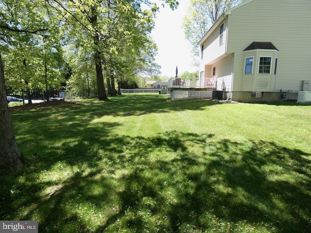 view of yard featuring a wooden deck and cooling unit