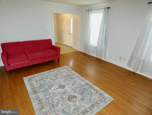living room featuring ornamental molding and wood finished floors
