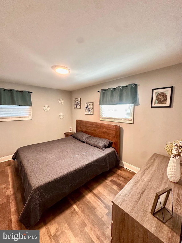 bedroom featuring baseboards and wood finished floors