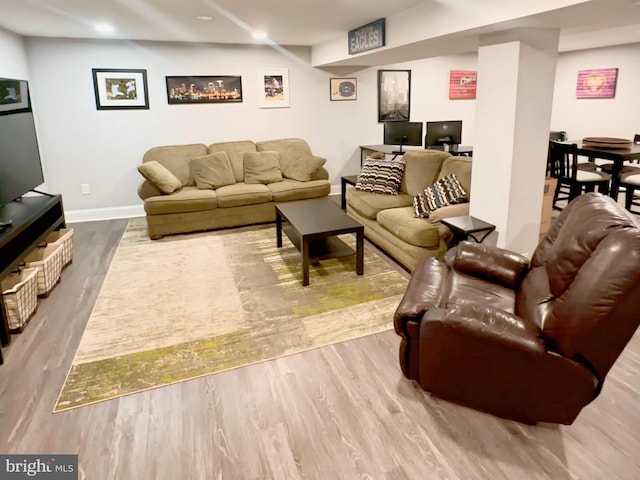 living area with baseboards and wood finished floors