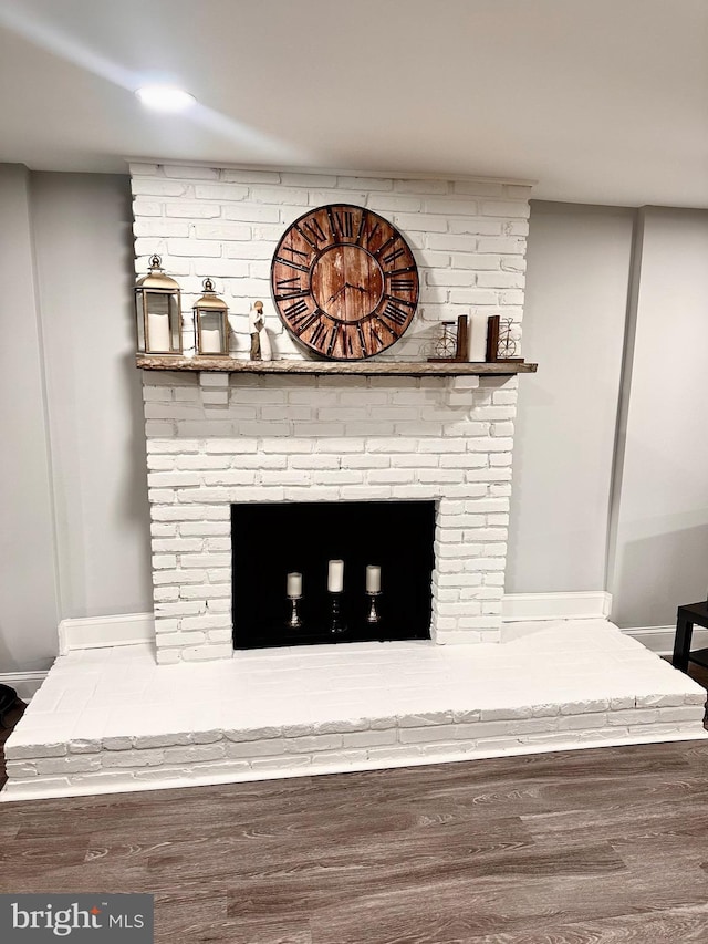 interior details with baseboards, wood finished floors, and a fireplace