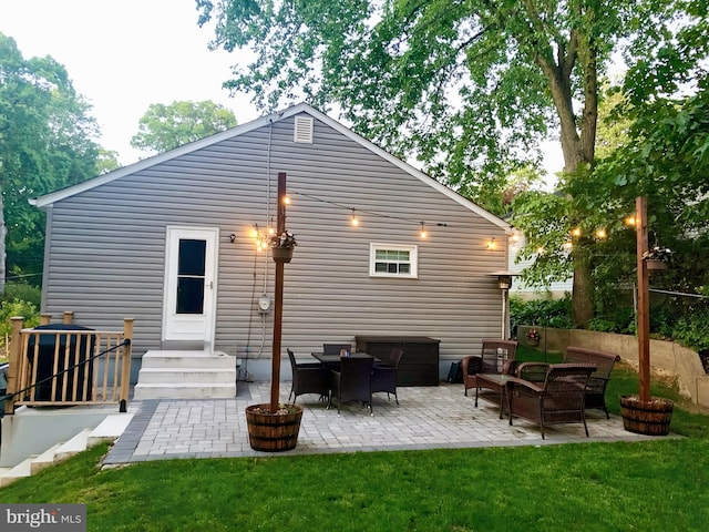 rear view of property featuring a yard, an outdoor living space, and a patio area