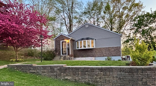 view of front of property featuring a front lawn and stone siding