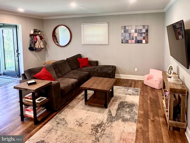living room with crown molding, baseboards, and wood finished floors