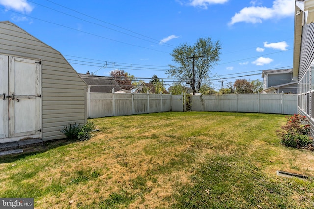 view of yard featuring a fenced backyard, an outbuilding, and a shed