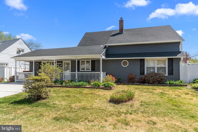 view of front of property featuring a front lawn, roof with shingles, covered porch, and a chimney