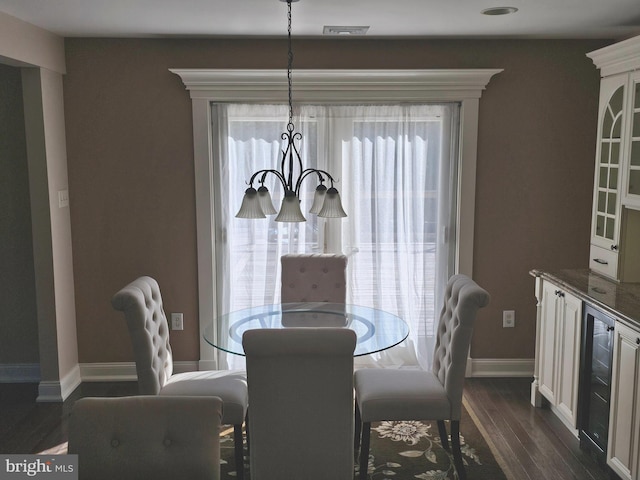 dining room with baseboards, an inviting chandelier, and dark wood finished floors