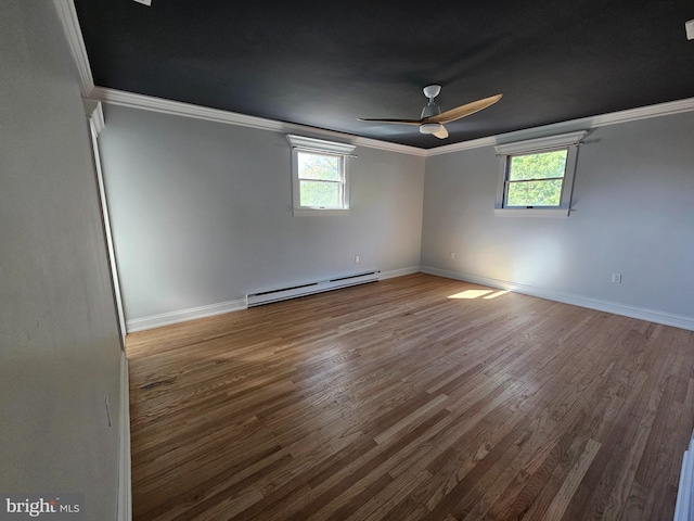 empty room with a healthy amount of sunlight, ornamental molding, and a baseboard heating unit