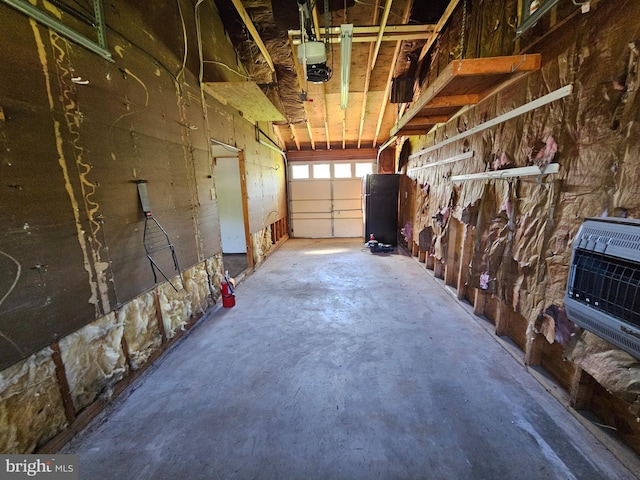 garage featuring heating unit and a garage door opener