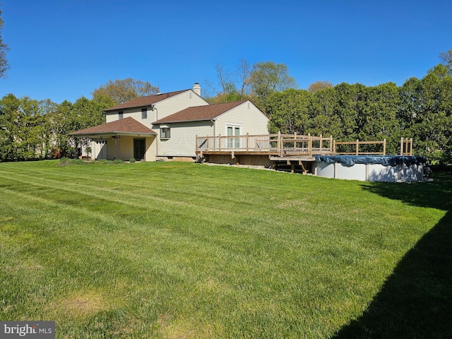 view of yard with a wooden deck and a covered pool