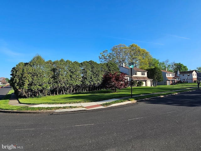 view of street featuring curbs, traffic signs, sidewalks, and a residential view