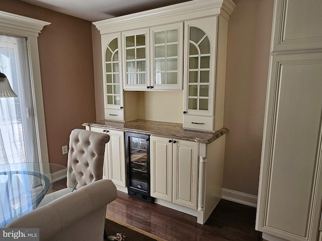 bar featuring a healthy amount of sunlight, baseboards, dark wood-style flooring, and beverage cooler