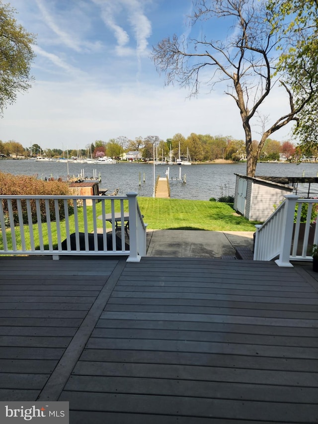 wooden terrace with a yard, a boat dock, and a water view