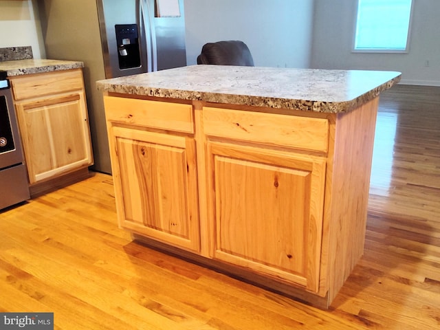 1048 Mill Rd, Woodstock, VA 22664 - kitchen featuring light brown cabinetry, a center island, light countertops, light wood finished floors, and range