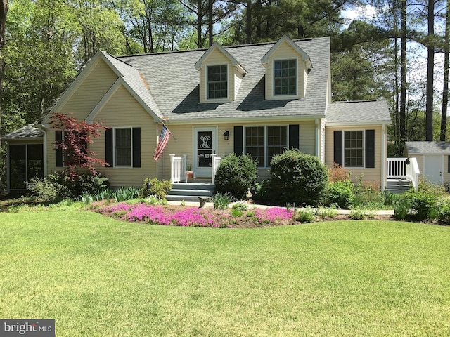 cape cod-style house with a shingled roof and a front yard