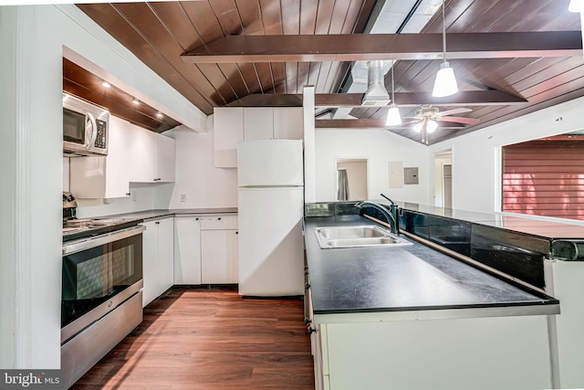 kitchen featuring white cabinets, dark countertops, appliances with stainless steel finishes, a sink, and vaulted ceiling with beams