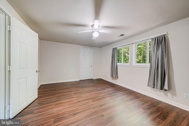 unfurnished bedroom featuring visible vents, baseboards, ceiling fan, and wood finished floors