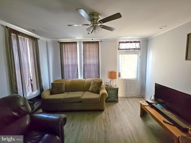 living area featuring crown molding, ceiling fan, wood finished floors, and baseboards