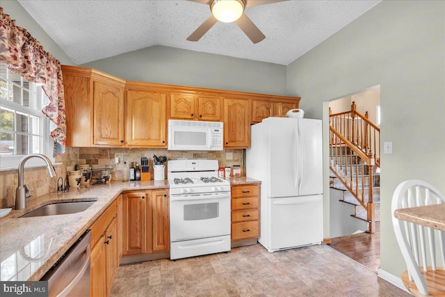 kitchen featuring a sink, tasteful backsplash, white appliances, and lofted ceiling