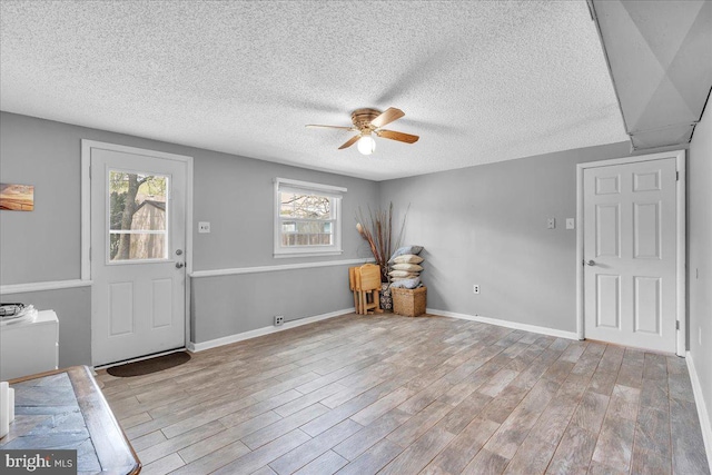 entrance foyer with ceiling fan, a healthy amount of sunlight, and wood finished floors