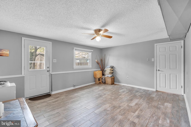 entryway with a ceiling fan, a textured ceiling, and wood finished floors